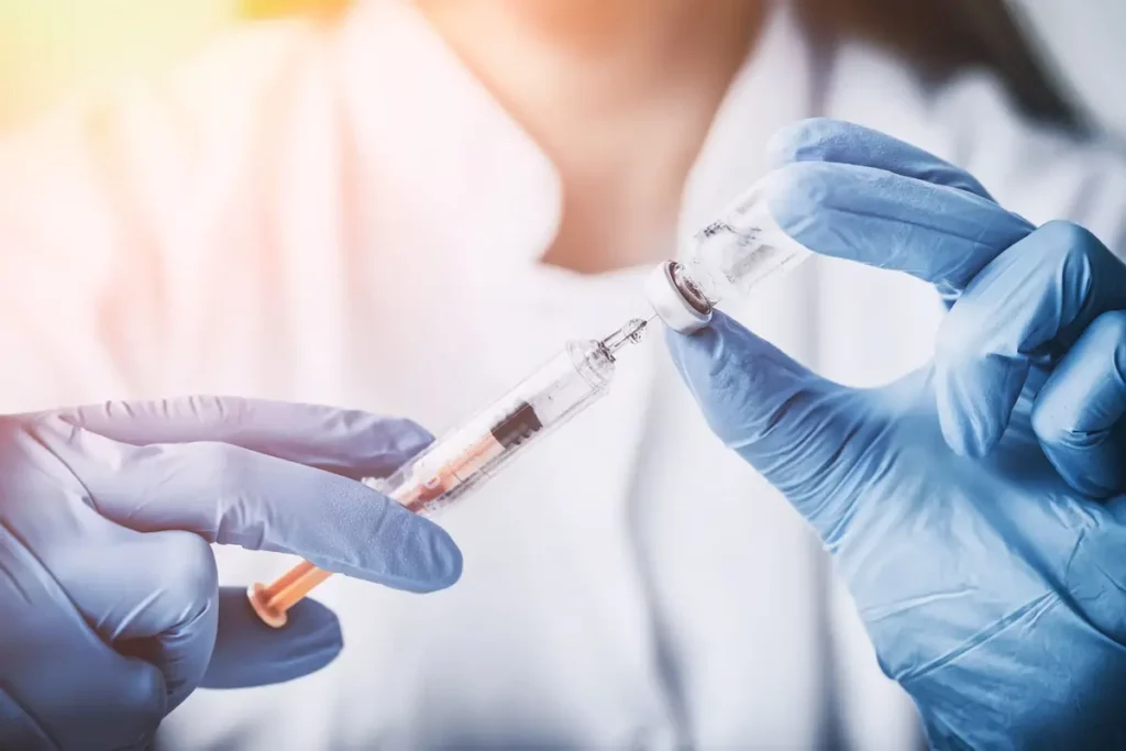 Gloved medical professional prepares a syringe with a vial, illustrating laboratory packages and diagnostic testing in Powell, WY.
