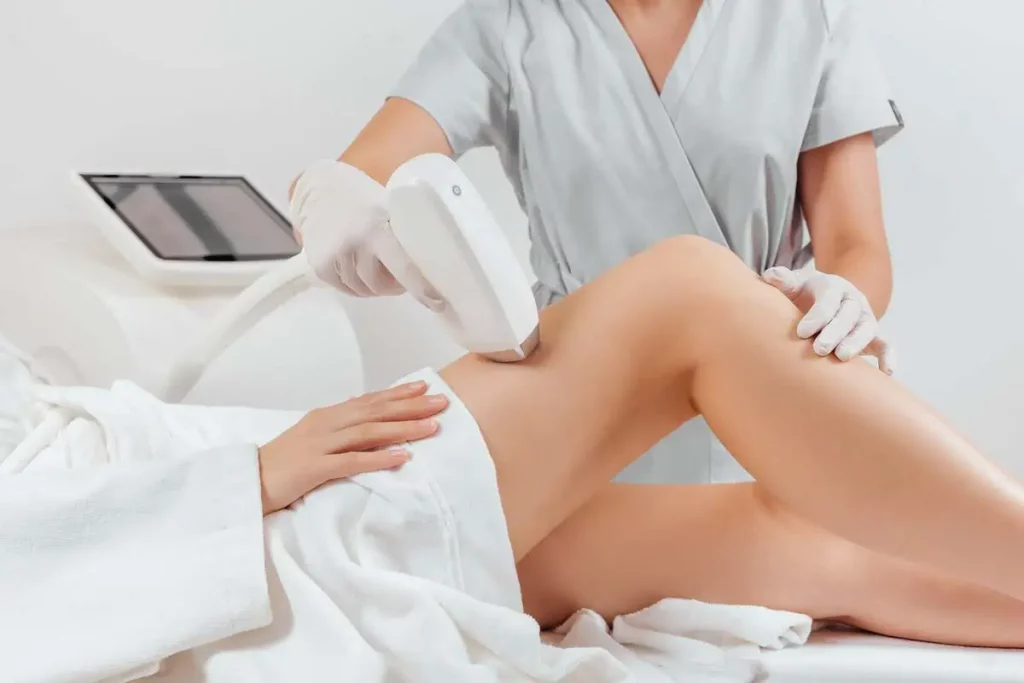 Gloved professional performs laser hair removal on a woman's thigh in Powell, WY.