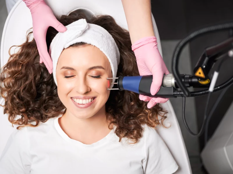 Gloved professional uses a handheld laser device for ablative skin resurfacing in Powell, WY.